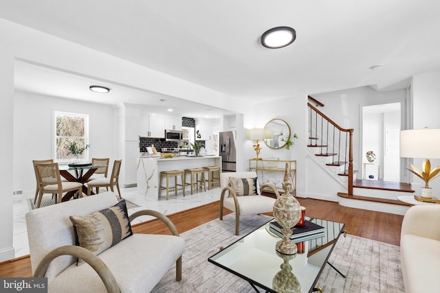 living room with light hardwood / wood-style floors and sink