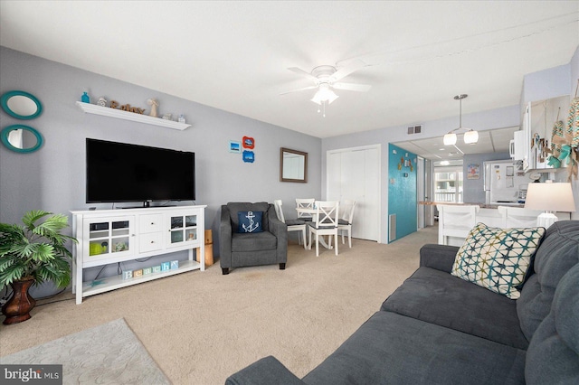 carpeted living room featuring ceiling fan