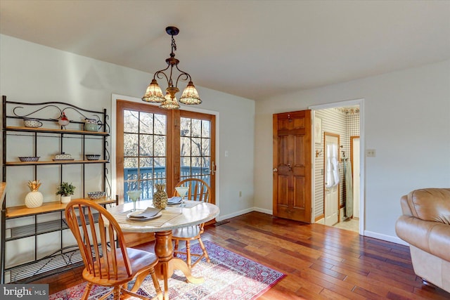 dining room featuring wood-type flooring and an inviting chandelier