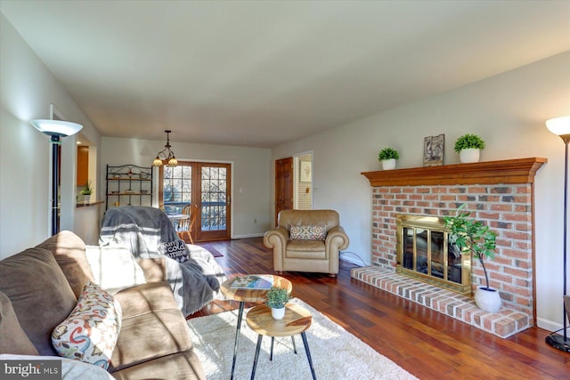 living room with a fireplace, dark hardwood / wood-style floors, and a notable chandelier