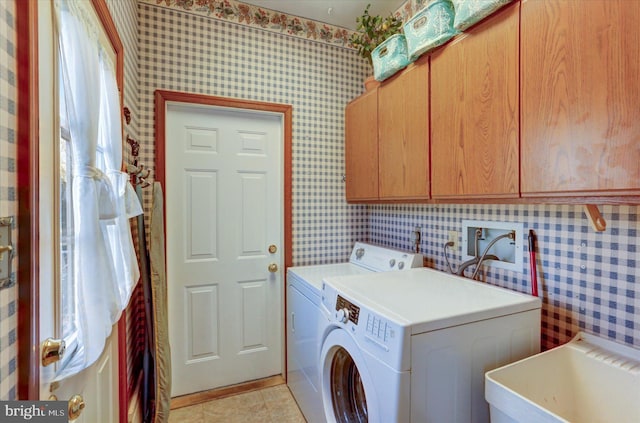 laundry room with cabinets, washing machine and dryer, light tile patterned floors, and sink