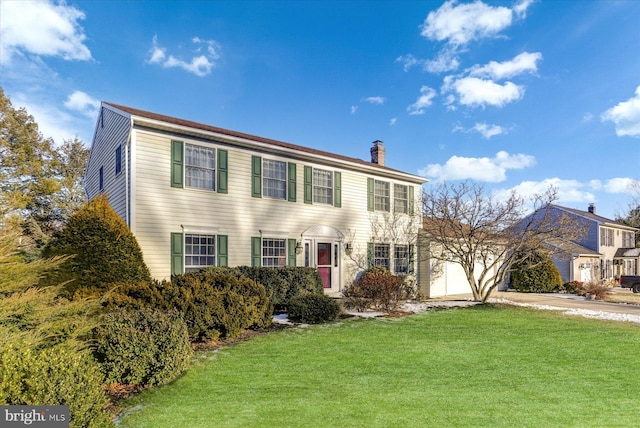 view of front of home with a front yard and a garage