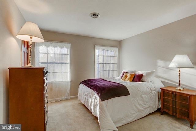 carpeted bedroom featuring multiple windows