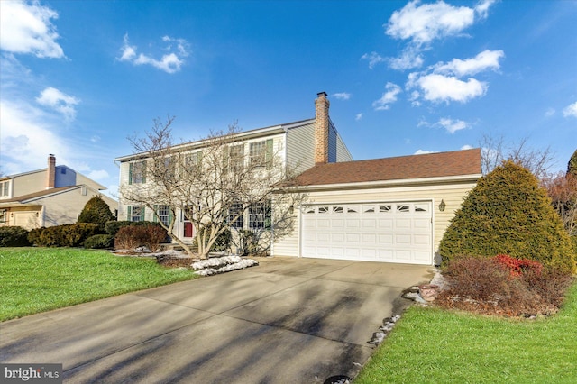 view of property featuring a front yard and a garage