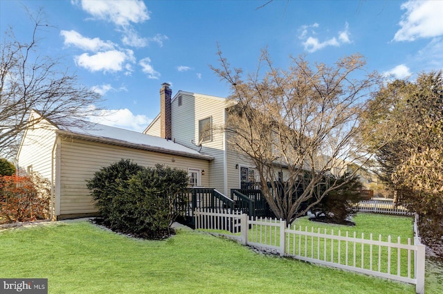 view of home's exterior with a deck and a lawn