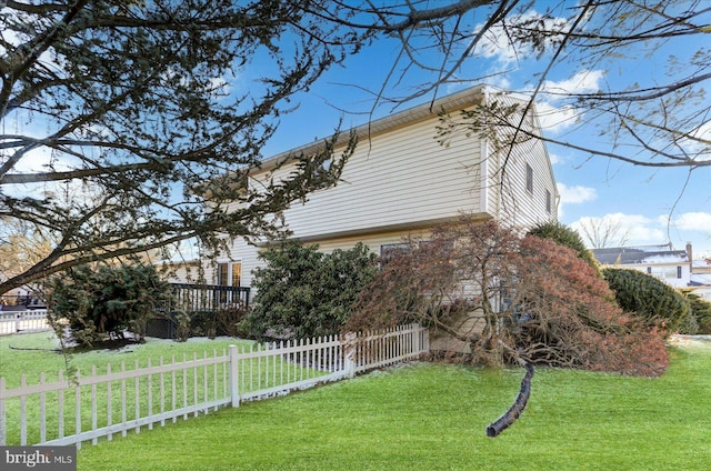 view of side of home with a lawn and a wooden deck