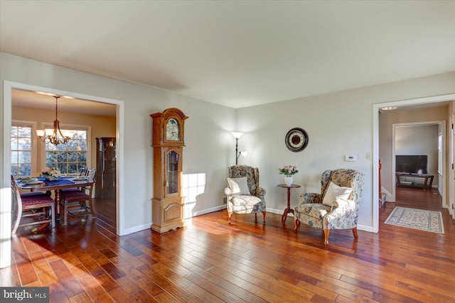 sitting room with dark hardwood / wood-style floors and an inviting chandelier