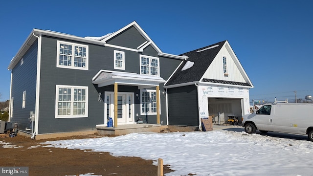 view of front of house featuring an attached garage, a standing seam roof, metal roof, and board and batten siding