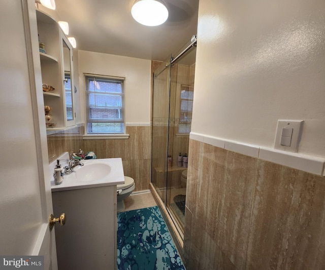 bathroom featuring tile patterned flooring, vanity, toilet, and a shower with shower door