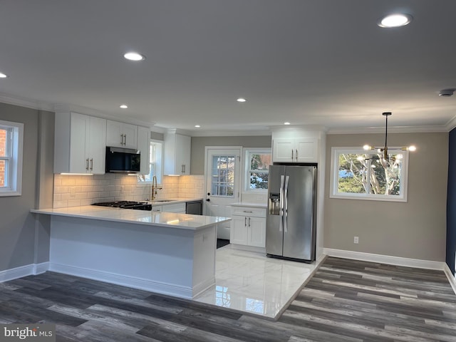 kitchen with white cabinets, stainless steel refrigerator with ice dispenser, decorative light fixtures, and ornamental molding