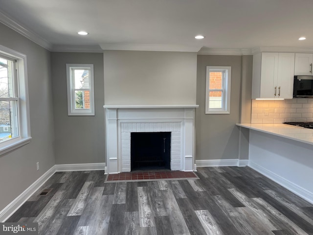 unfurnished living room featuring a fireplace, dark hardwood / wood-style floors, and ornamental molding