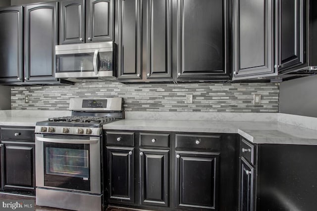 kitchen with light stone countertops, backsplash, and stainless steel appliances