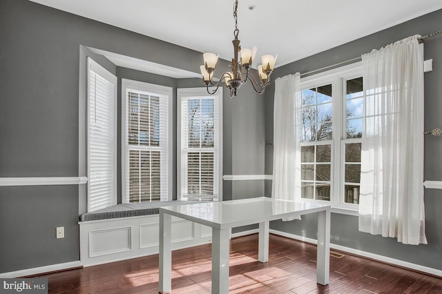 unfurnished dining area featuring a chandelier and hardwood / wood-style flooring