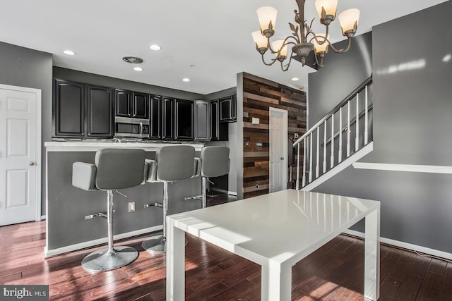 dining area with dark hardwood / wood-style floors and a notable chandelier