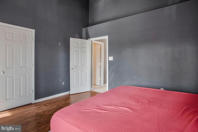 bedroom featuring a high ceiling and hardwood / wood-style floors