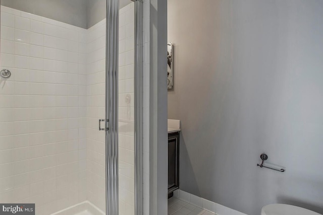 bathroom with tile patterned floors, toilet, an enclosed shower, and vanity