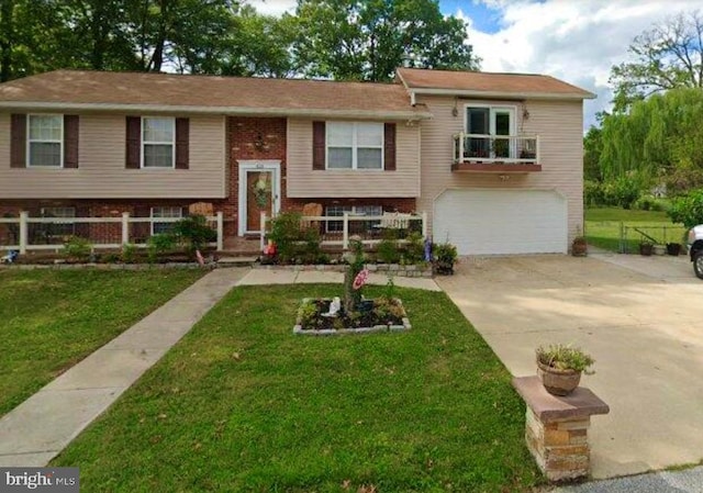 bi-level home featuring a balcony, a front lawn, and a garage