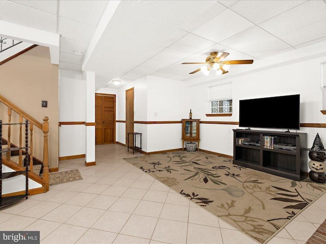 living room featuring ceiling fan, light tile patterned floors, and a paneled ceiling