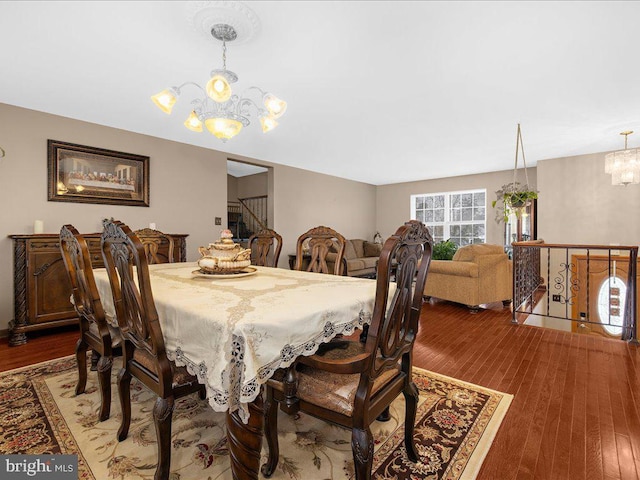 dining space featuring wood-type flooring and a notable chandelier