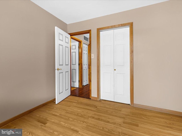 unfurnished bedroom with a closet and light hardwood / wood-style floors