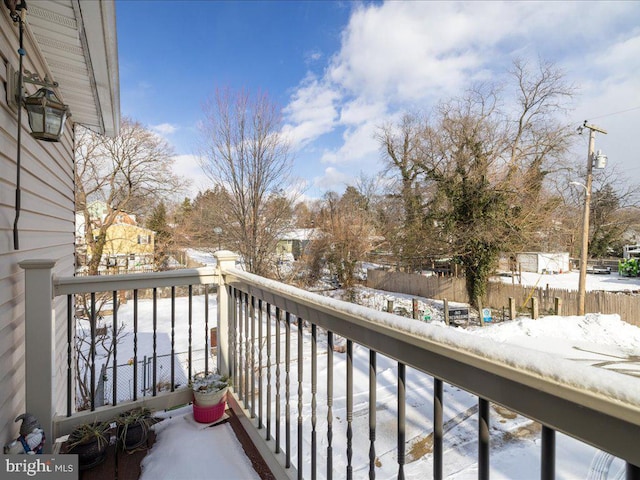 view of snow covered back of property