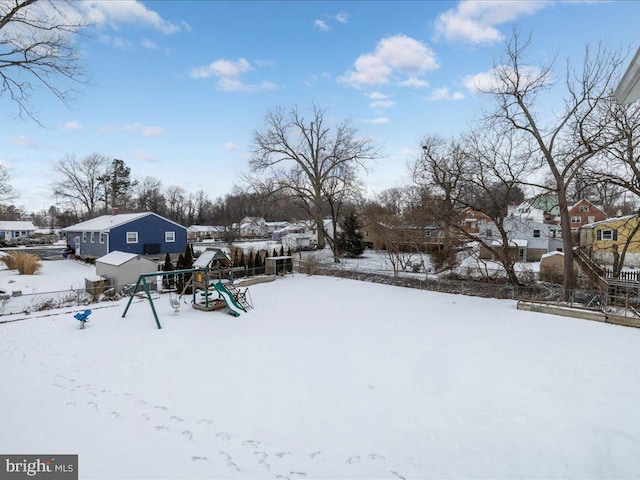 yard layered in snow with a playground