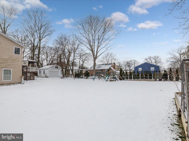 yard covered in snow featuring a playground and an outdoor structure