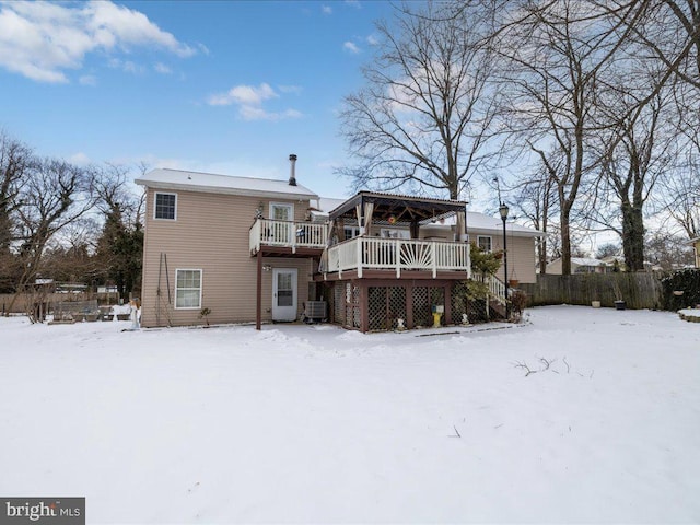 snow covered rear of property featuring a deck and cooling unit