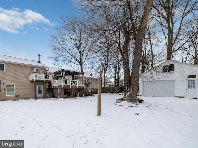 yard layered in snow with a deck and a garage