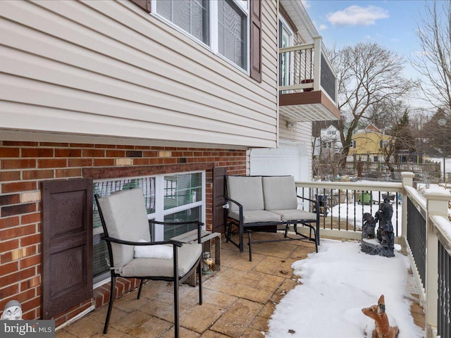 snow covered patio with a balcony