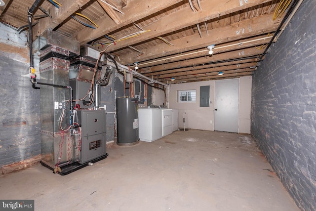 basement featuring washing machine and dryer, water heater, brick wall, electric panel, and heating unit