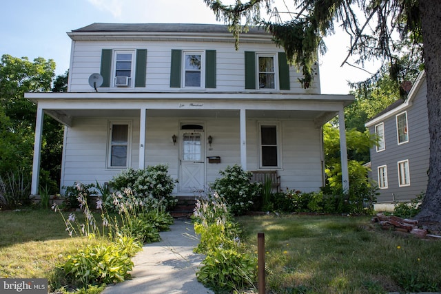 view of front of property with a front lawn and cooling unit