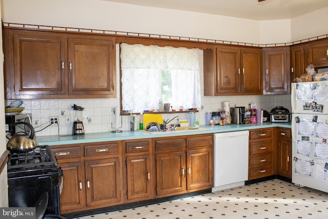 kitchen with backsplash, white appliances, and sink