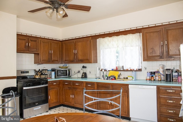 kitchen featuring backsplash, ceiling fan, sink, and stainless steel appliances