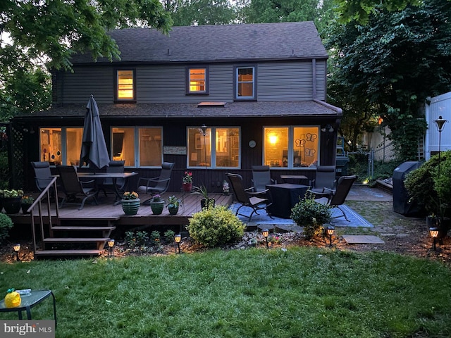 back of property featuring a lawn and a wooden deck