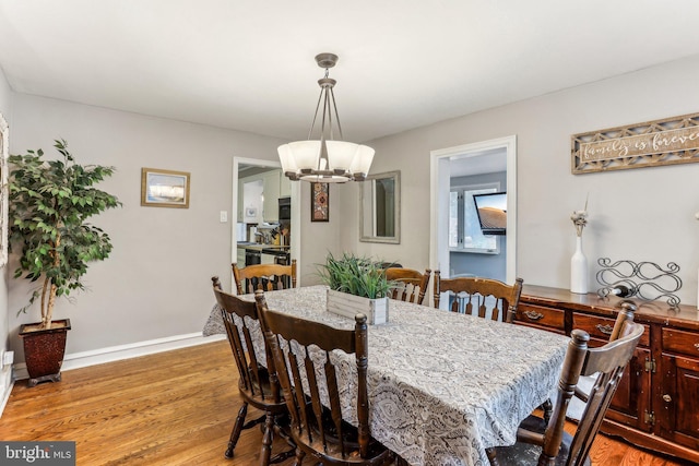 dining space featuring light hardwood / wood-style flooring and a notable chandelier