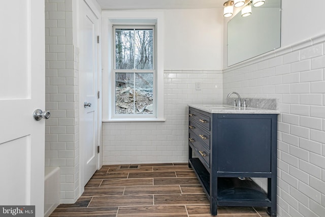 bathroom with vanity and tile walls