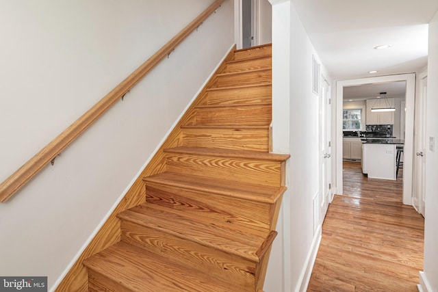 stairs featuring hardwood / wood-style floors