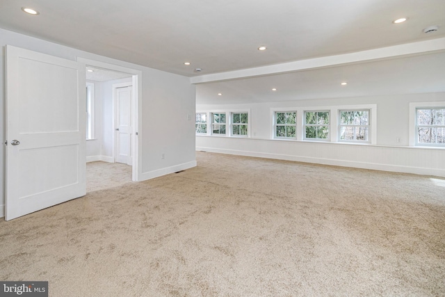 interior space featuring beam ceiling and light carpet