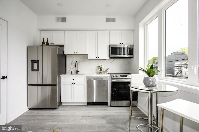 kitchen with appliances with stainless steel finishes, sink, and white cabinets