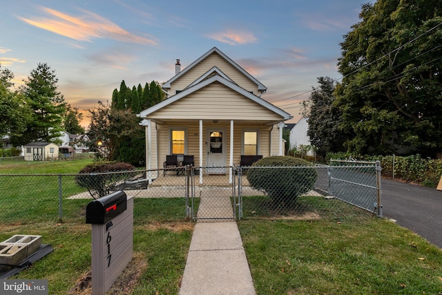 bungalow-style house featuring covered porch and a yard