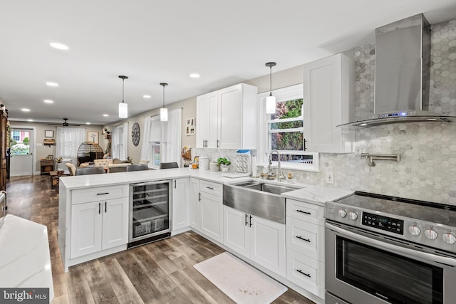 kitchen featuring wine cooler, wall chimney exhaust hood, sink, white cabinetry, and stainless steel electric range