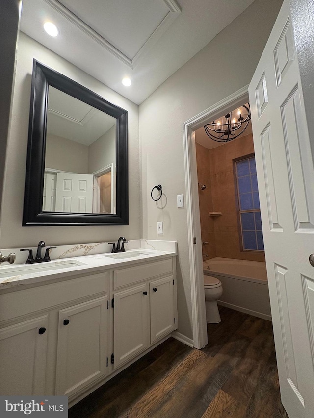 full bathroom featuring bathtub / shower combination, hardwood / wood-style floors, toilet, vanity, and a notable chandelier