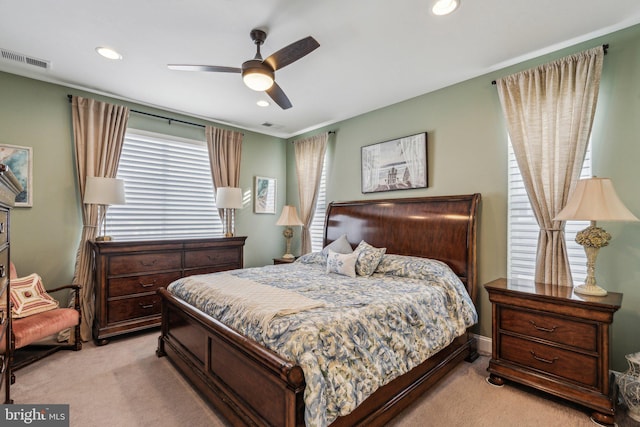 bedroom with multiple windows, ceiling fan, and light colored carpet