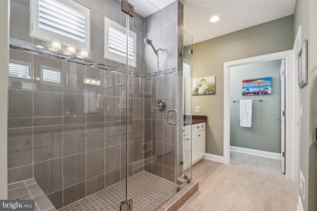 bathroom featuring tile patterned floors, a shower with door, and vanity