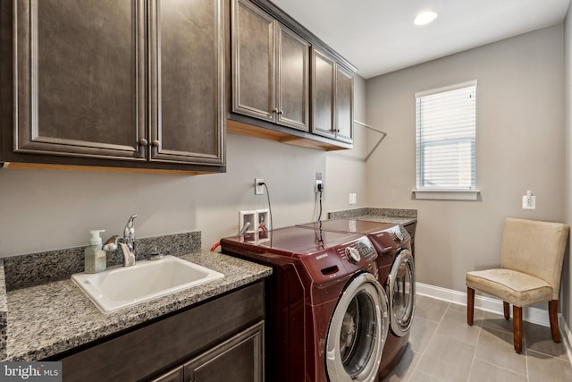 laundry room with cabinets, light tile patterned floors, sink, and washing machine and clothes dryer