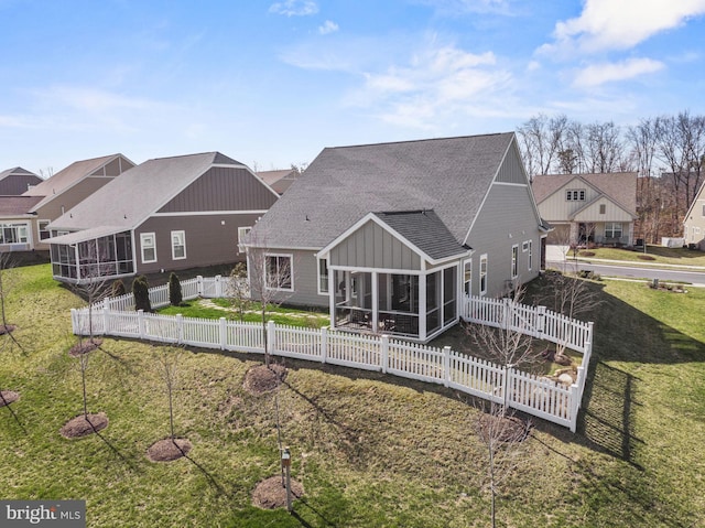 back of house featuring a yard and a sunroom