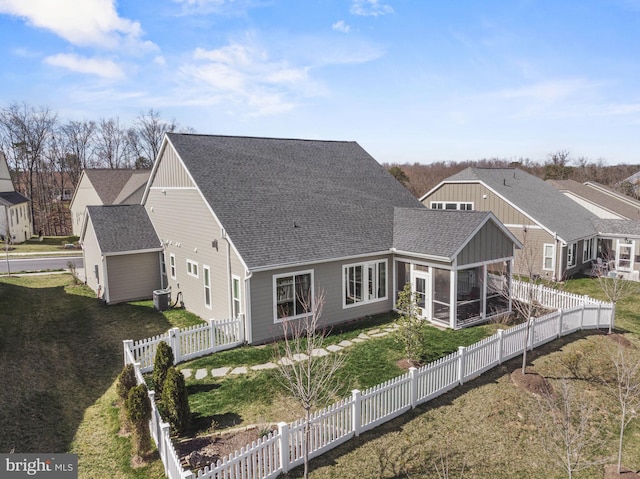 back of house with a lawn, a sunroom, and central AC unit