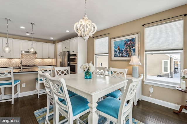 dining room featuring a notable chandelier, dark hardwood / wood-style flooring, and sink