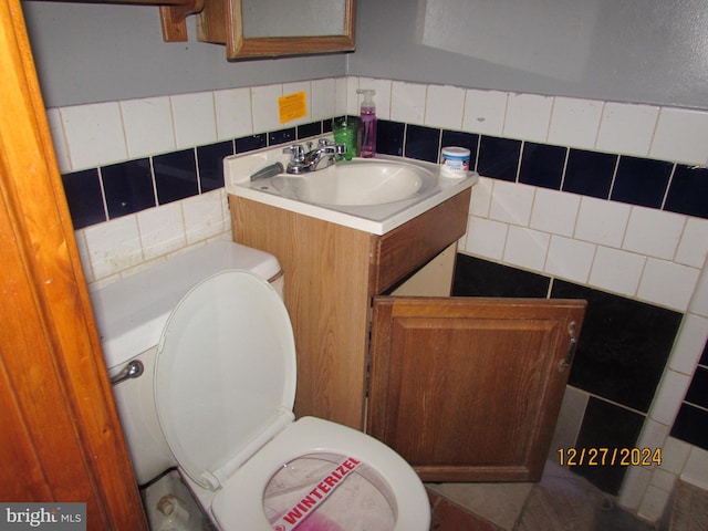 bathroom featuring vanity, toilet, and decorative backsplash